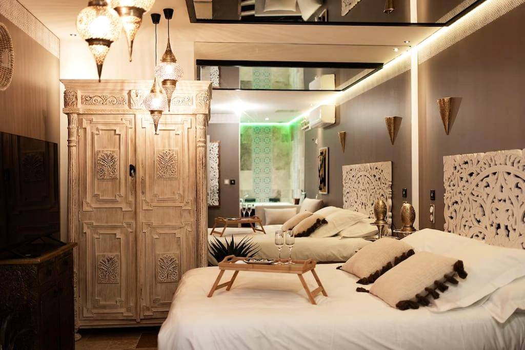 Chambre avec lit double et armoire sculptée - Love Room Saint - Rambert - d'Albon - Love Room 1001 nuits & Balnéo