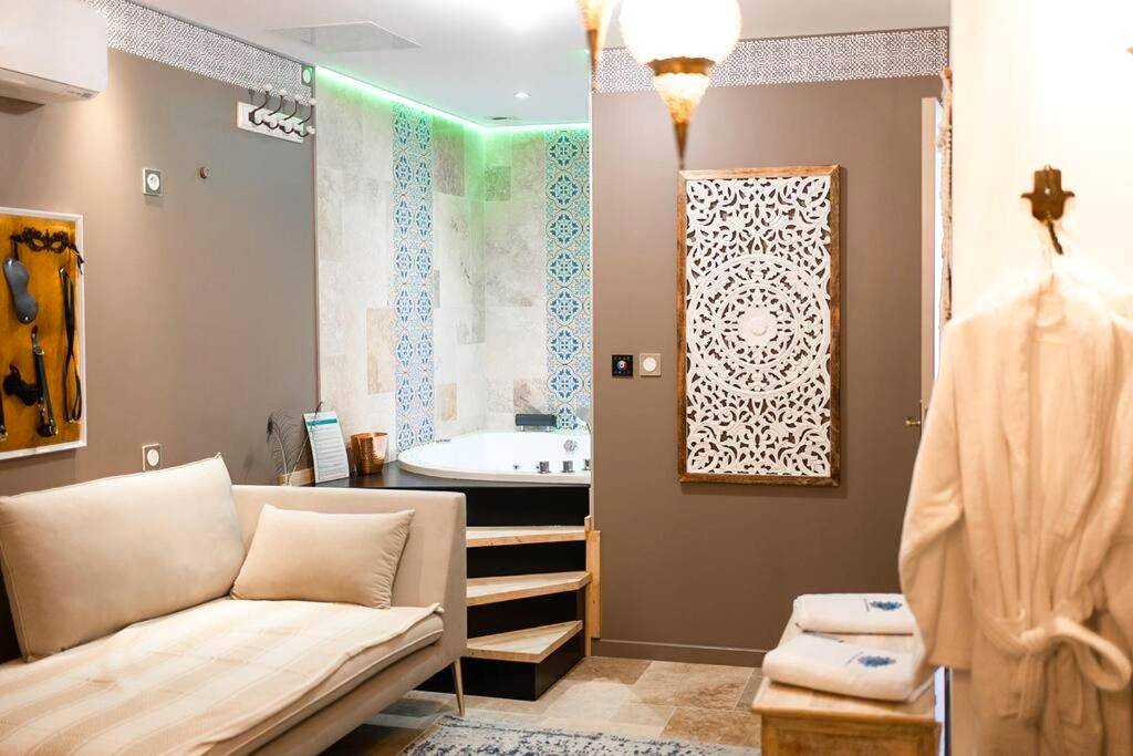 Baignoire balnéo ronde et canapé de détente - Love Room 1001 nuits & Balnéo