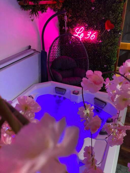Jacuzzi avec éclairage bleu et fauteuil suspendu - Love Room Bellevaux - Le 36/Espace bien - être privatif