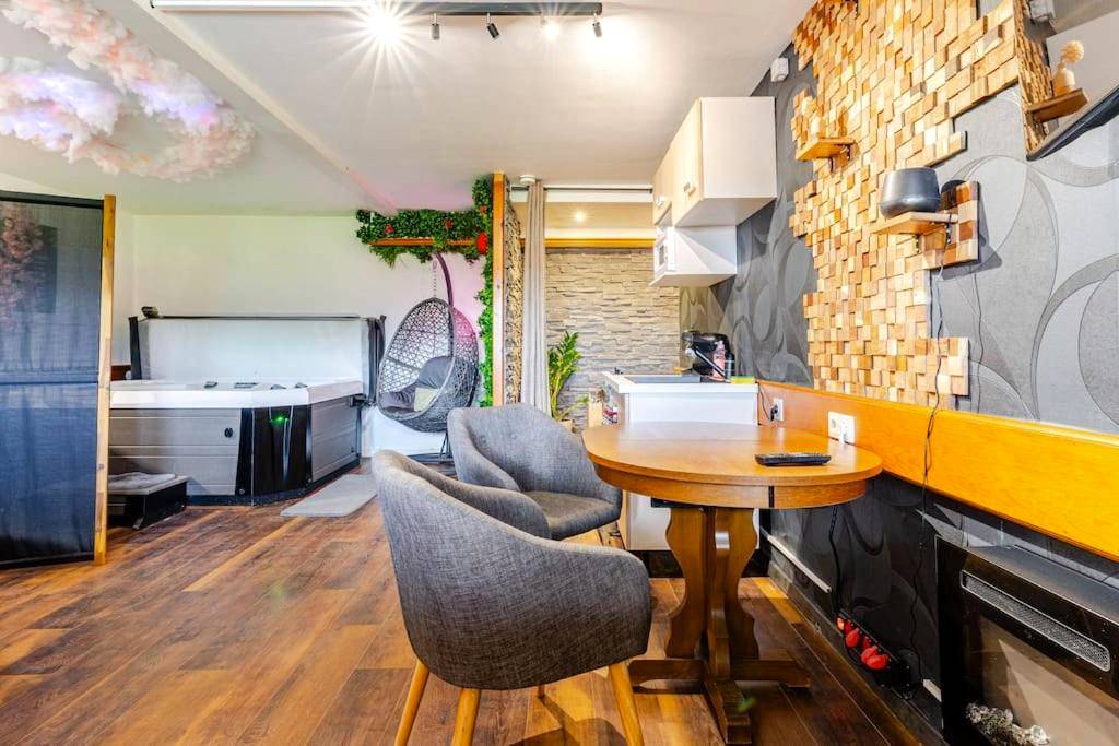 Espace repas avec table ronde et fauteuils gris - Le 36/Espace bien - être privatif