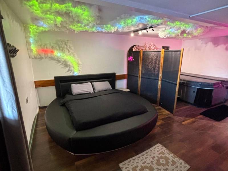 Chambre avec lit rond et jacuzzi en arrière - plan - Le 36/Espace bien - être privatif