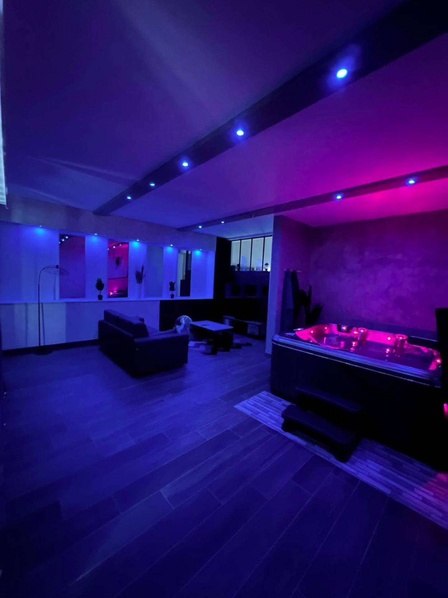 Salon et jacuzzi avec éclairage néon bleu - Love Room Besançon - LE 46 : Superbe appartement jacuzzi