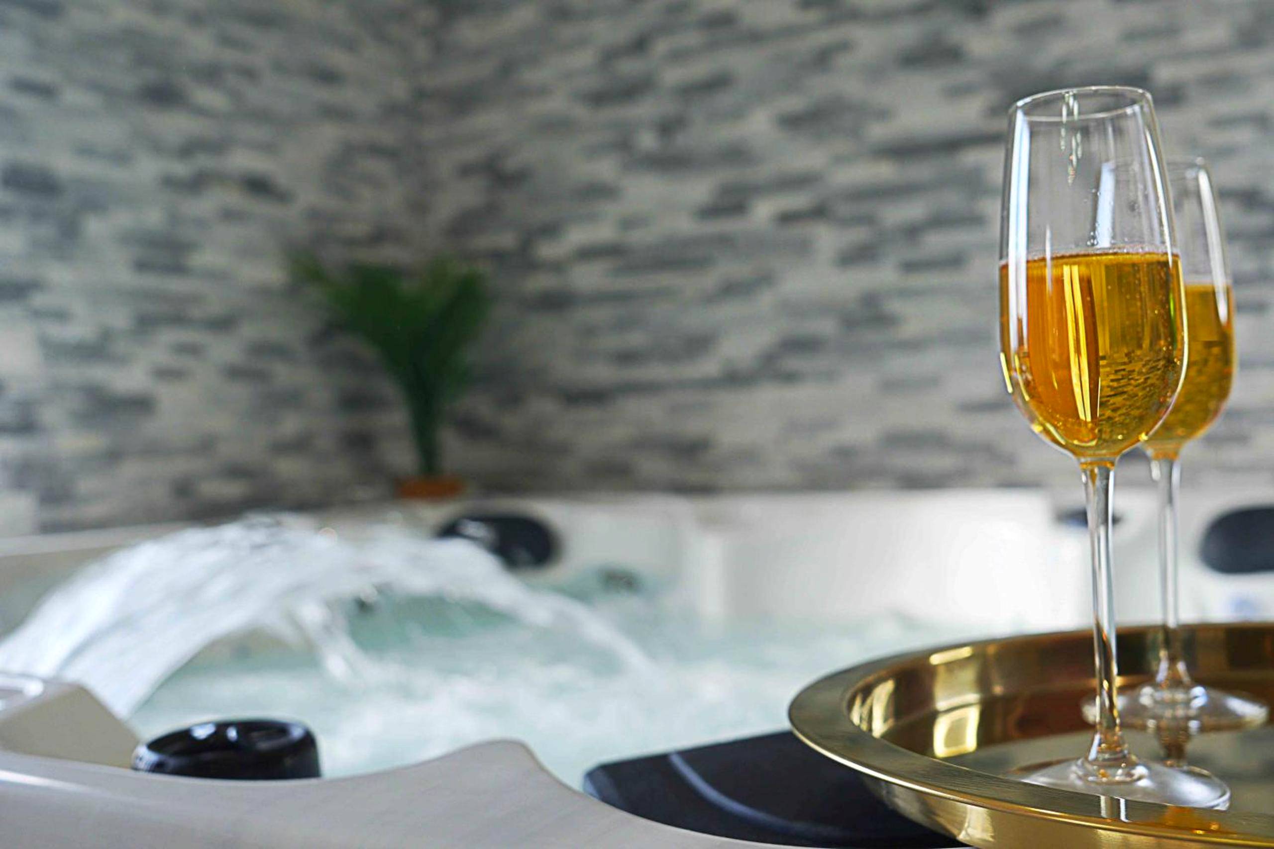 Flûtes de champagne devant un jacuzzi - Love Room Viels - Maisons - 4AS Spa Paris