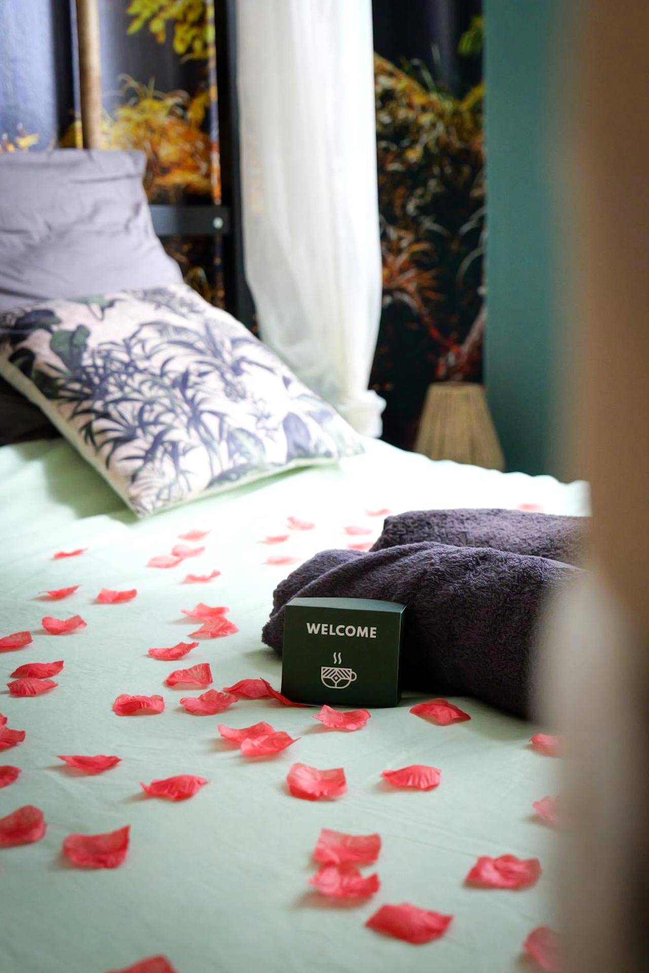 Détail de lit avec pétales de rose et cadeaux - 50 Nuances Nirvana - Love Room à Rouen