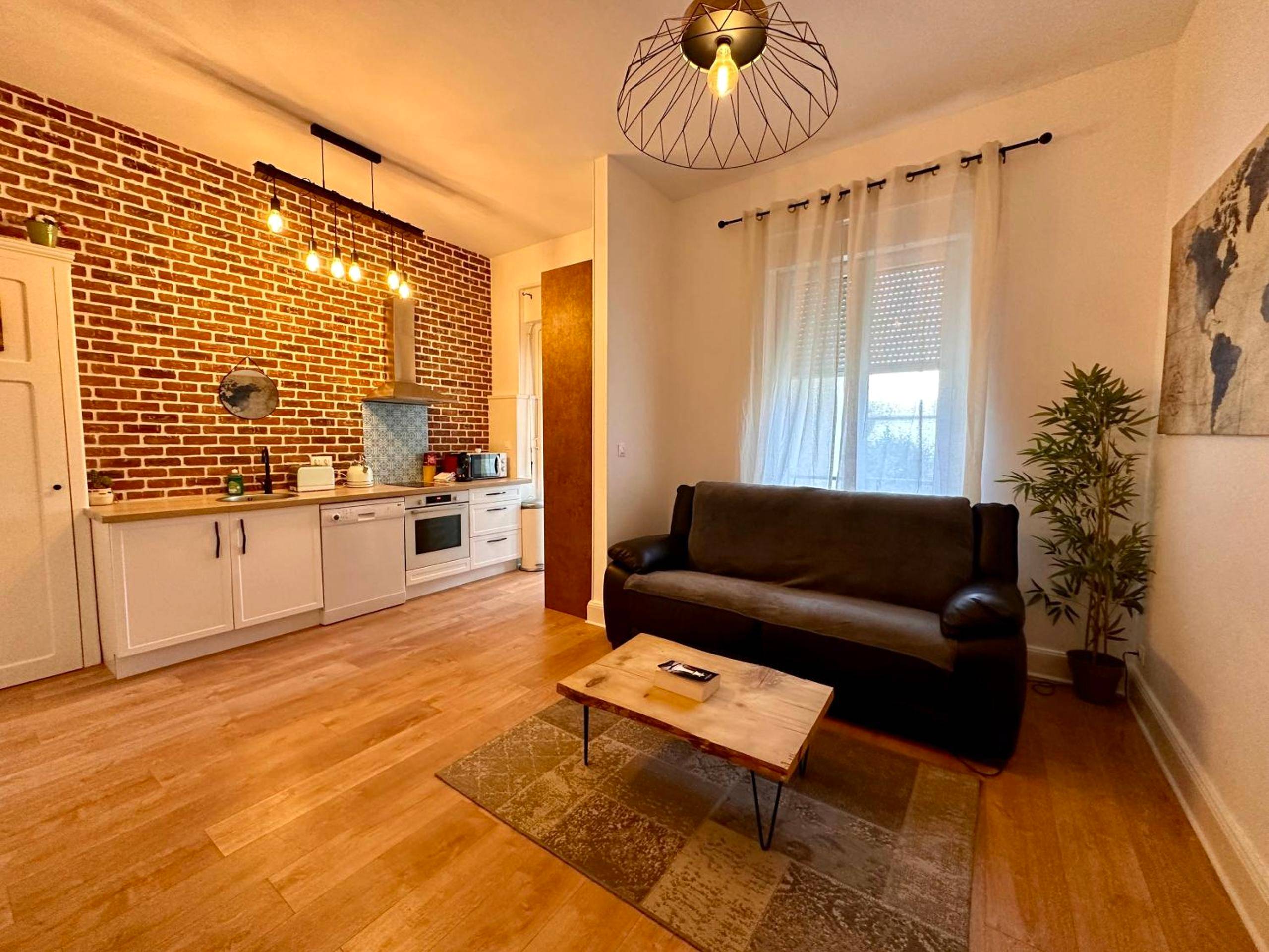 Salon ouvert sur cuisine avec mur de briques - A0 Grand Appartement, Jaccuzi, et extérieur Thermal Artem à 200m
