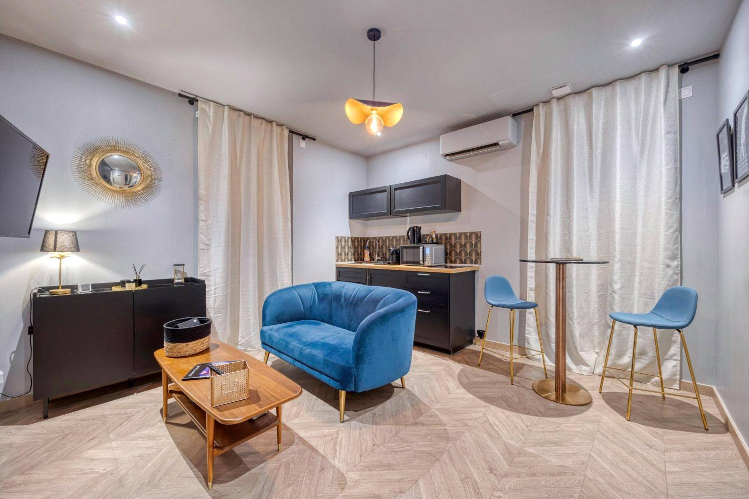 Salon avec canapé bleu et coin cuisine - Love Room L'Aixtase - Oasis Romantique à Aix - les - Bains