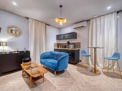 Salon avec canapé bleu et coin cuisine - Love Room L'Aixtase - Oasis Romantique à Aix - les - Bains