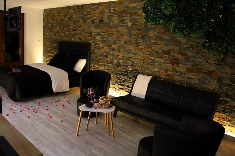 Espace salon et lit avec pétales de rose - L'Alchimie