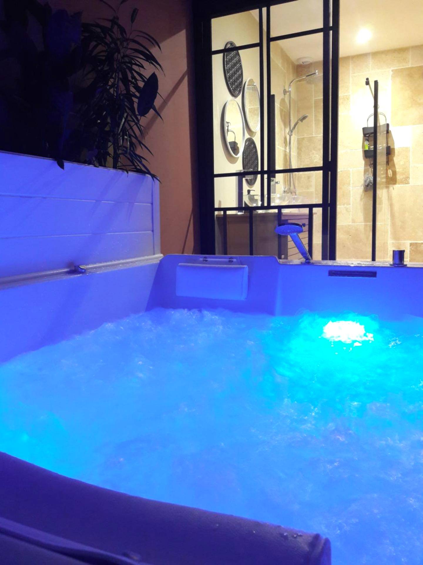 Jacuzzi privatif avec éclairage bleu néon - Love Room Caudrot - L'alchimie33