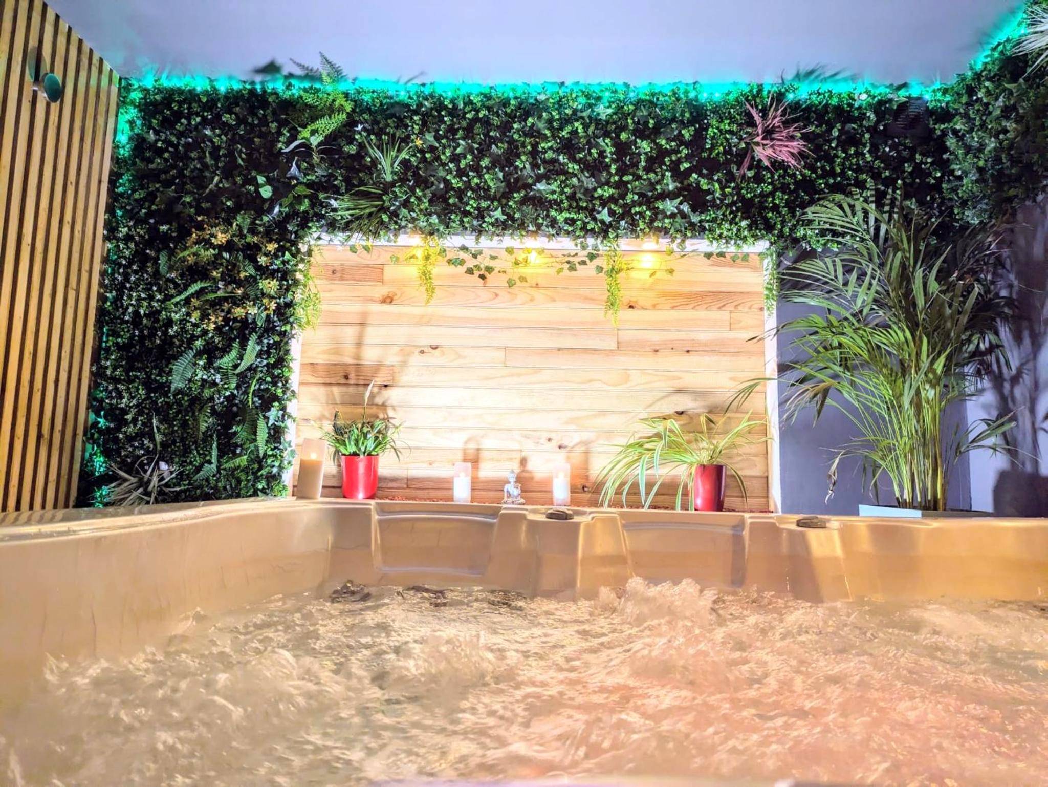 Détail du jacuzzi avec bougies et bois naturel - L'alcôve du 510 - Spa - chambre romantique - sauna - salle de jeux