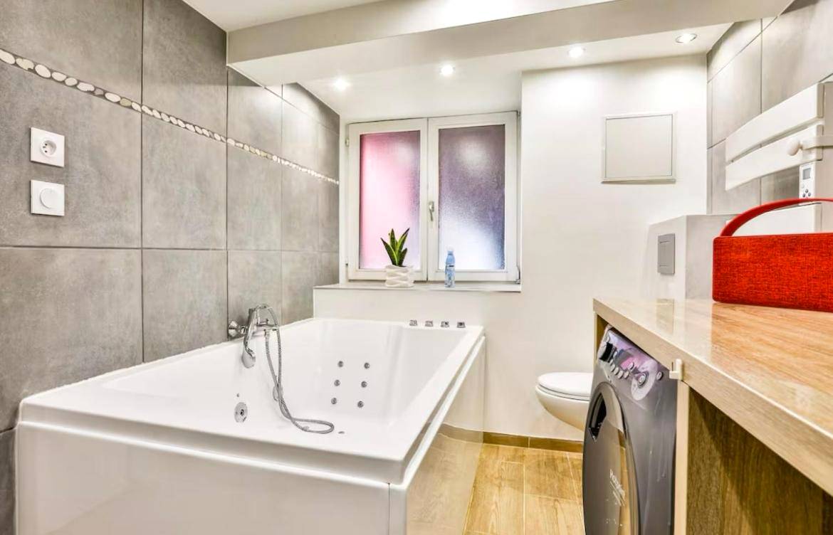 Salle de bain moderne avec baignoire spa - L’Alsacienne room et spa