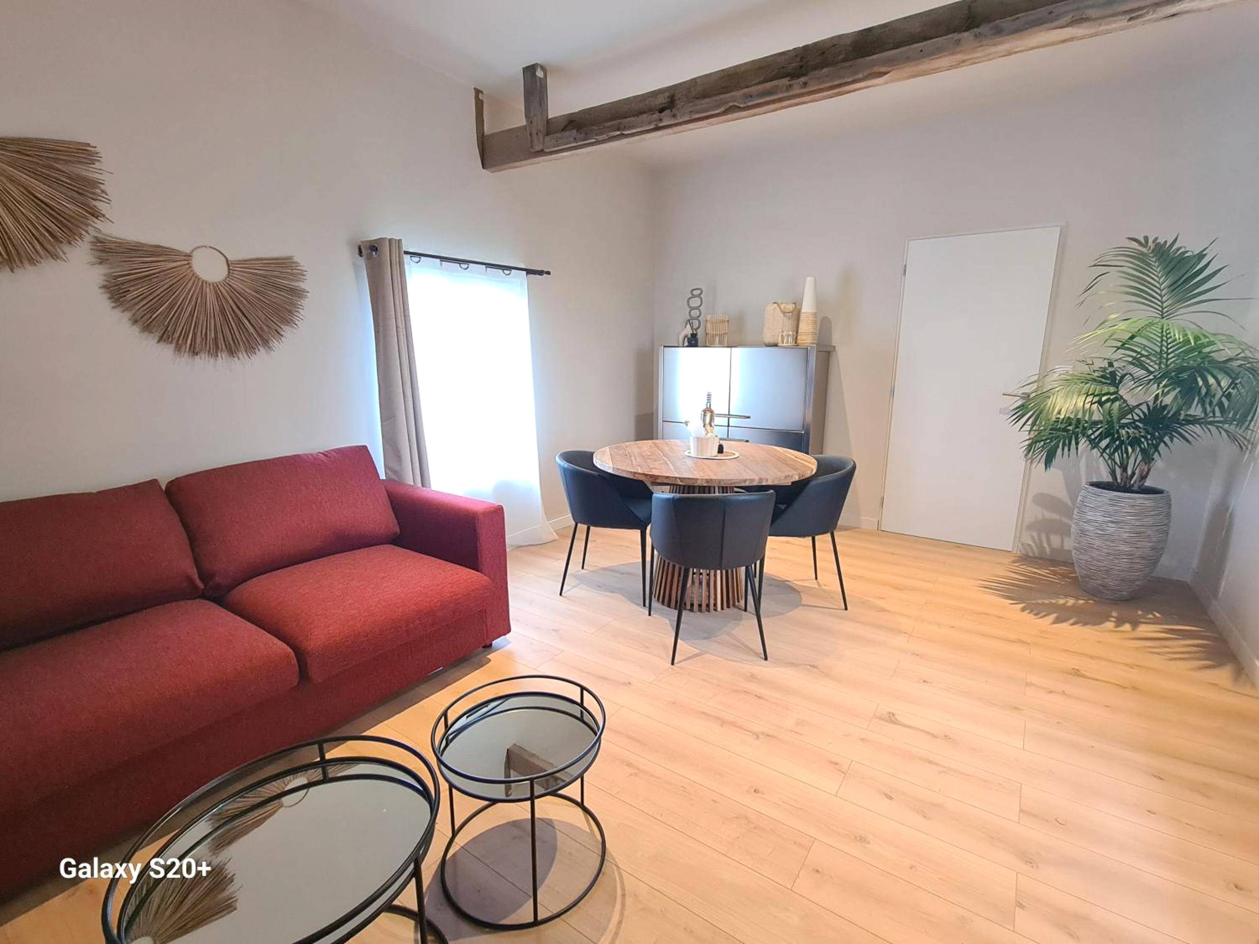 Salon avec canapé rouge et table ronde - Ame O des Flandres, La Suite