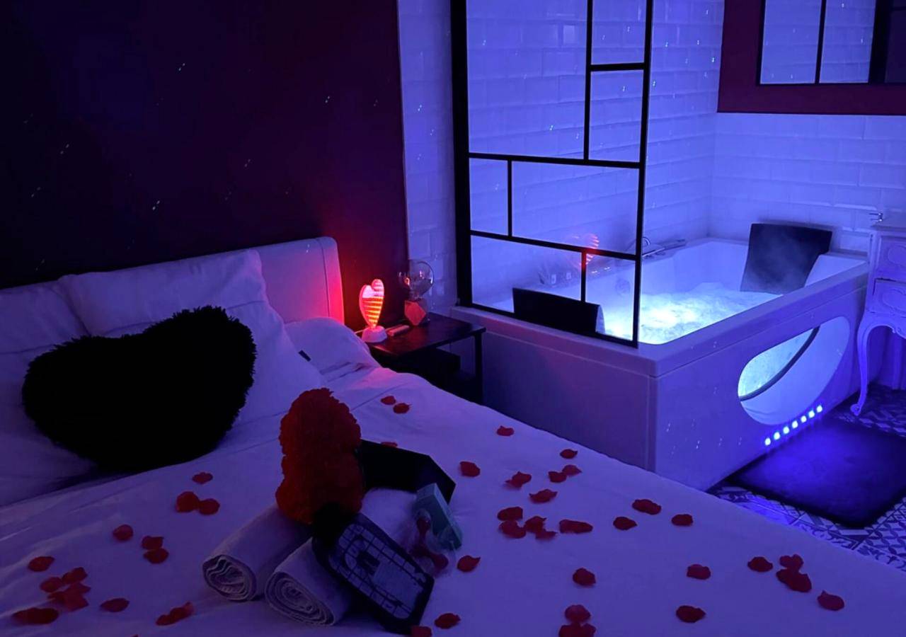 Lit avec pétales de rose et jacuzzi éclairé - Love Room Vallauris - Amour Azur Appartement pour 2 avec jacuzzi et...