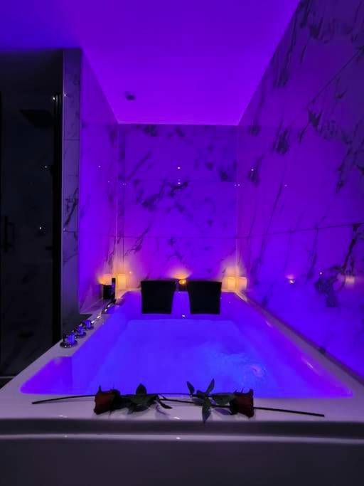 Jacuzzi privatif avec éclairage violet - Love Room Montbrison - LOVE ROOM - Amour Chic et Intime