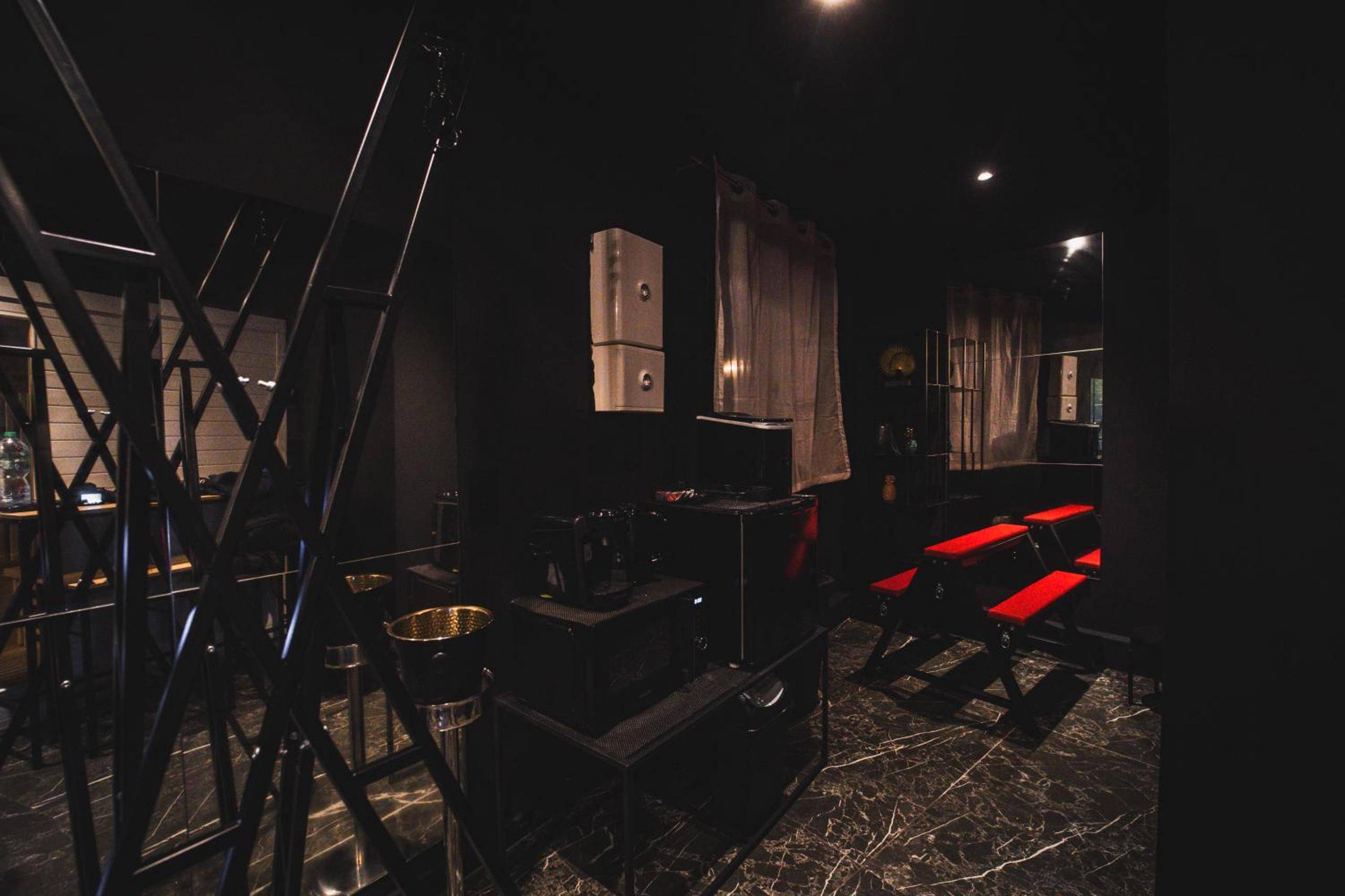 Espace salon noir avec mobilier BDSM - Love Room Sarcelles - Amour d'une Nuit, LoveRoom