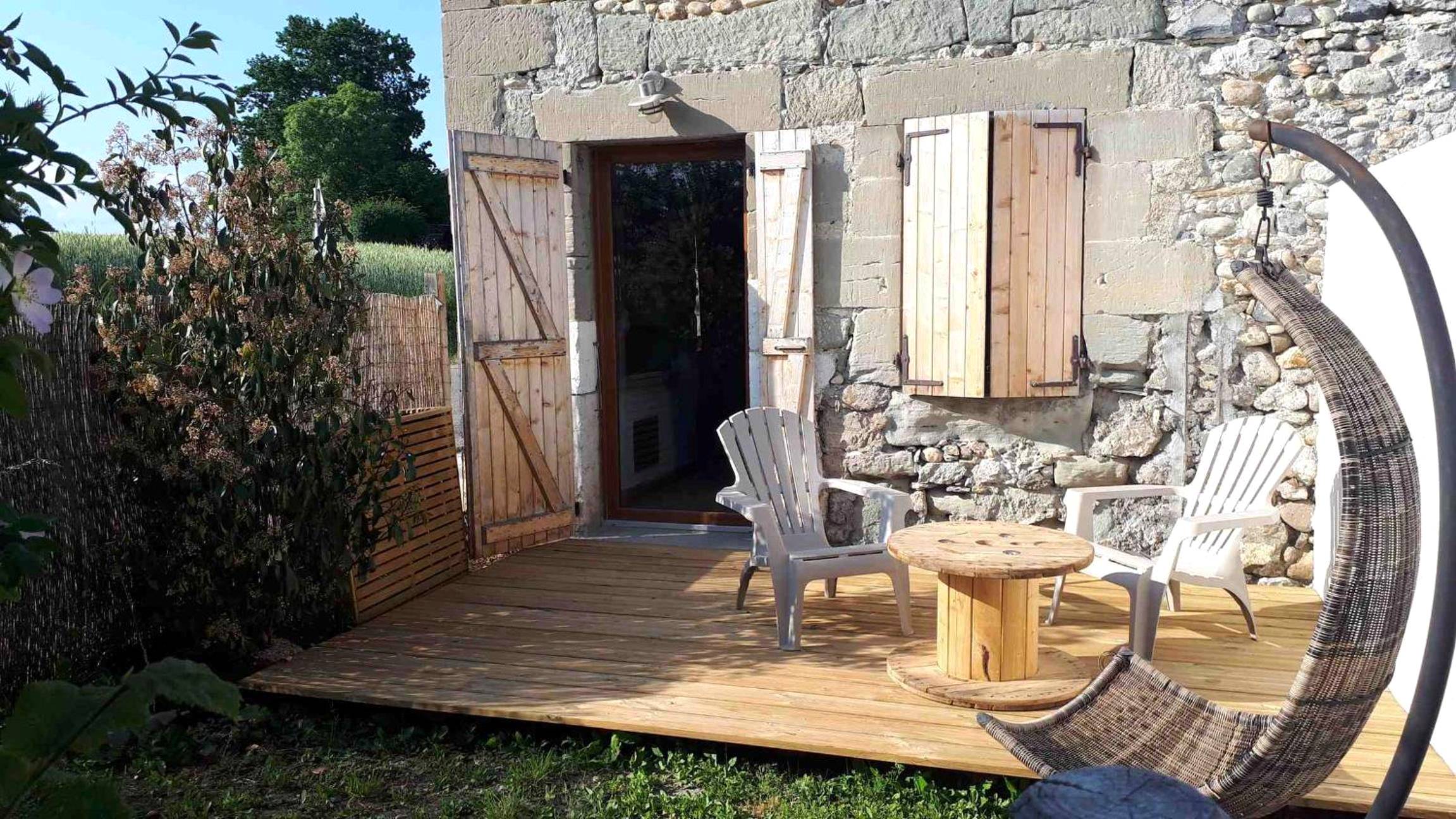 Terrasse en bois avec fauteuils et table basse - GITE Chambre SPA Privé DE L'ANCIENNE FERME