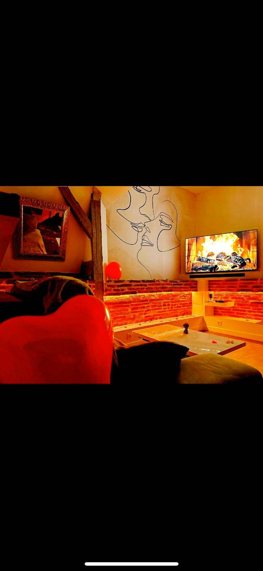 Salon chaleureux avec fresque murale et TV - Love Room Belberaud - L'Antre vue - jacuzzi au château