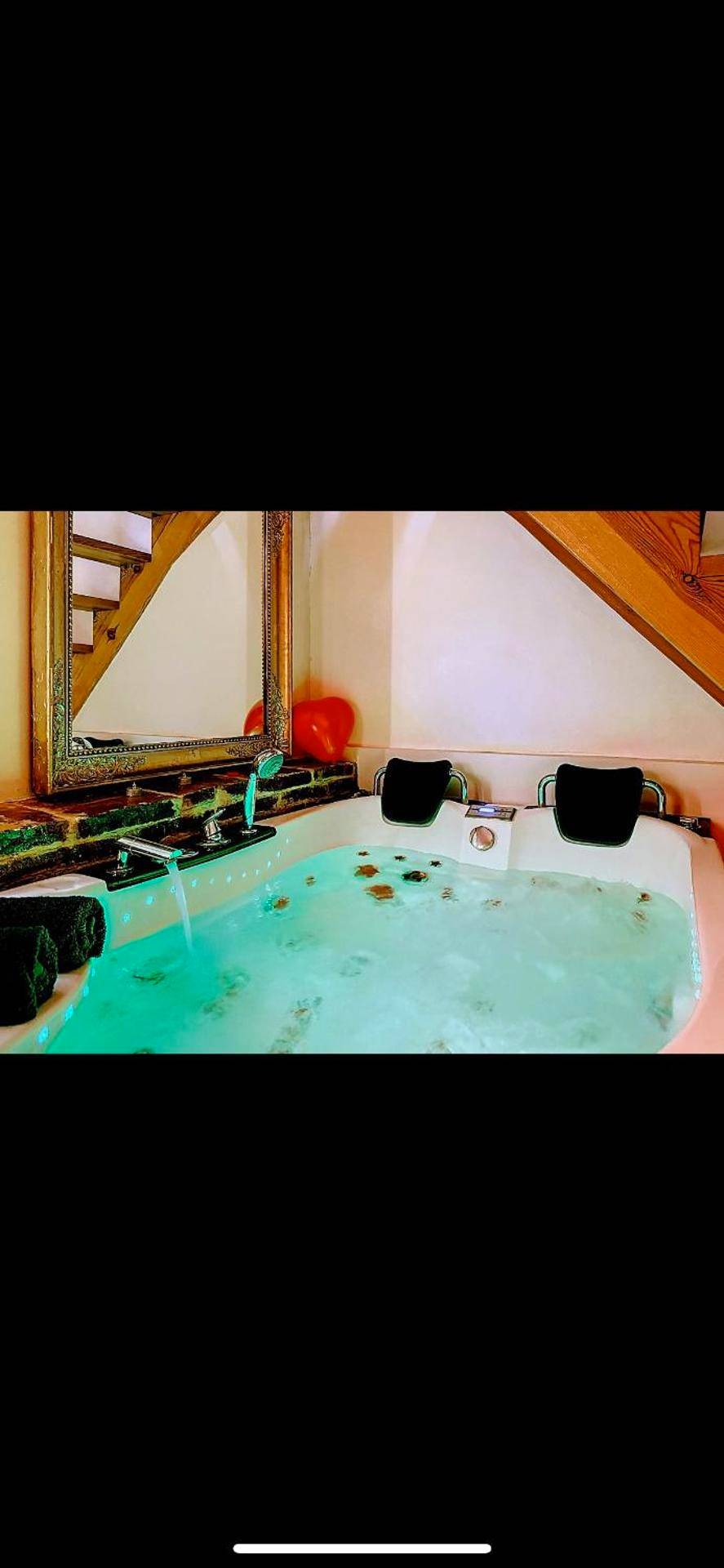Jacuzzi privatif avec éclairage bleu et miroir - L'Antre vue - jacuzzi au château