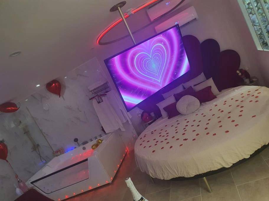Lit rond avec pétales et jacuzzi privatif - Love Room Maraussan - Aphrodisia loveconcept