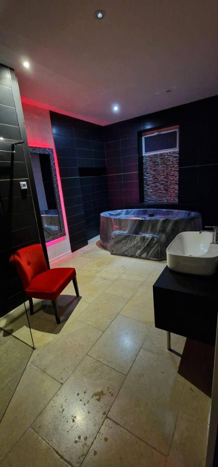 Espace bien - être avec jacuzzi et fauteuil rouge - L'Aphrodite Jacuzzi privatif