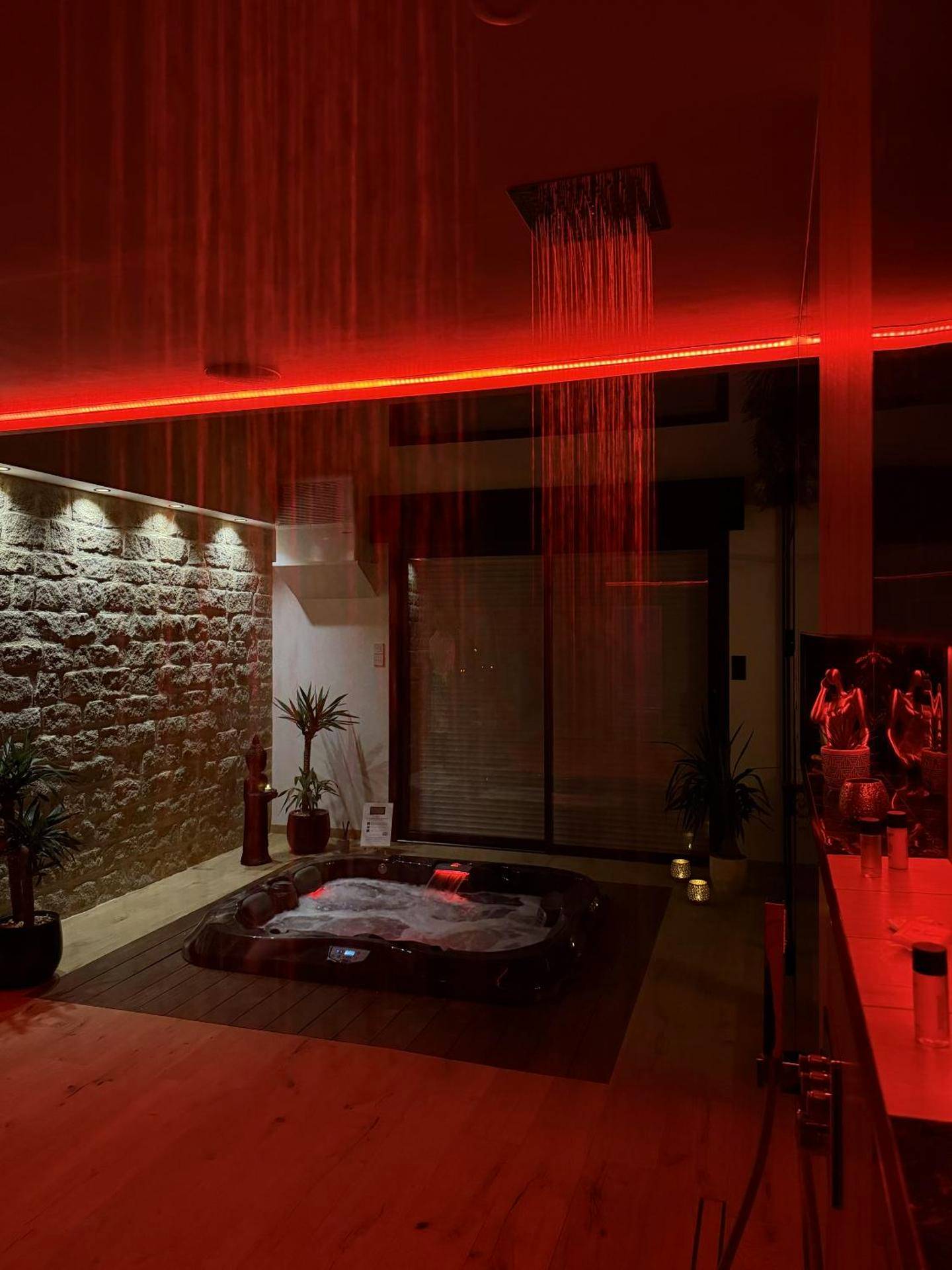 Jacuzzi avec cascade sous éclairage rouge - L'Apogée