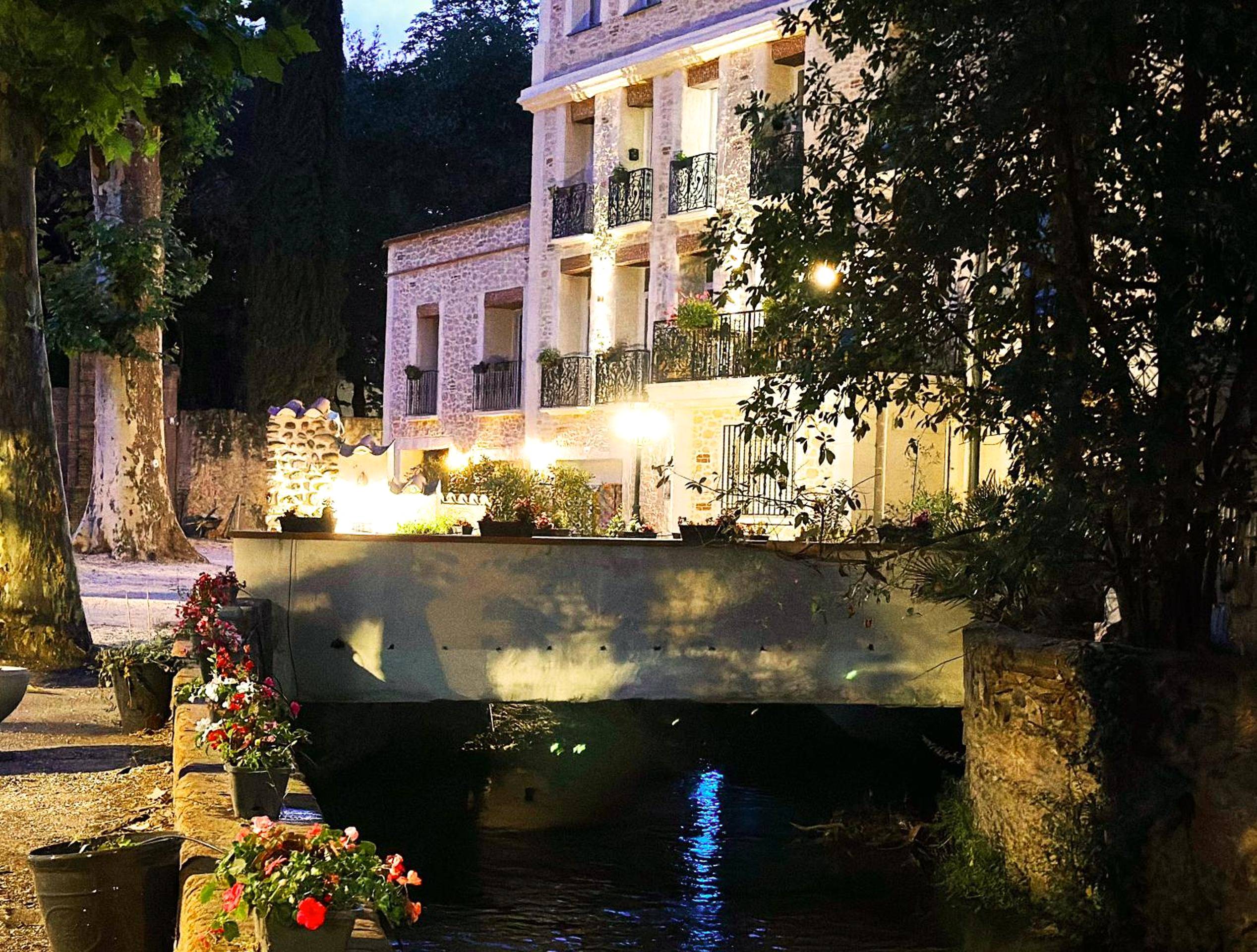 Façade en pierre au bord de l'eau de nuit - Love Room Perpignan - Appart Hotel Spa Perpignan