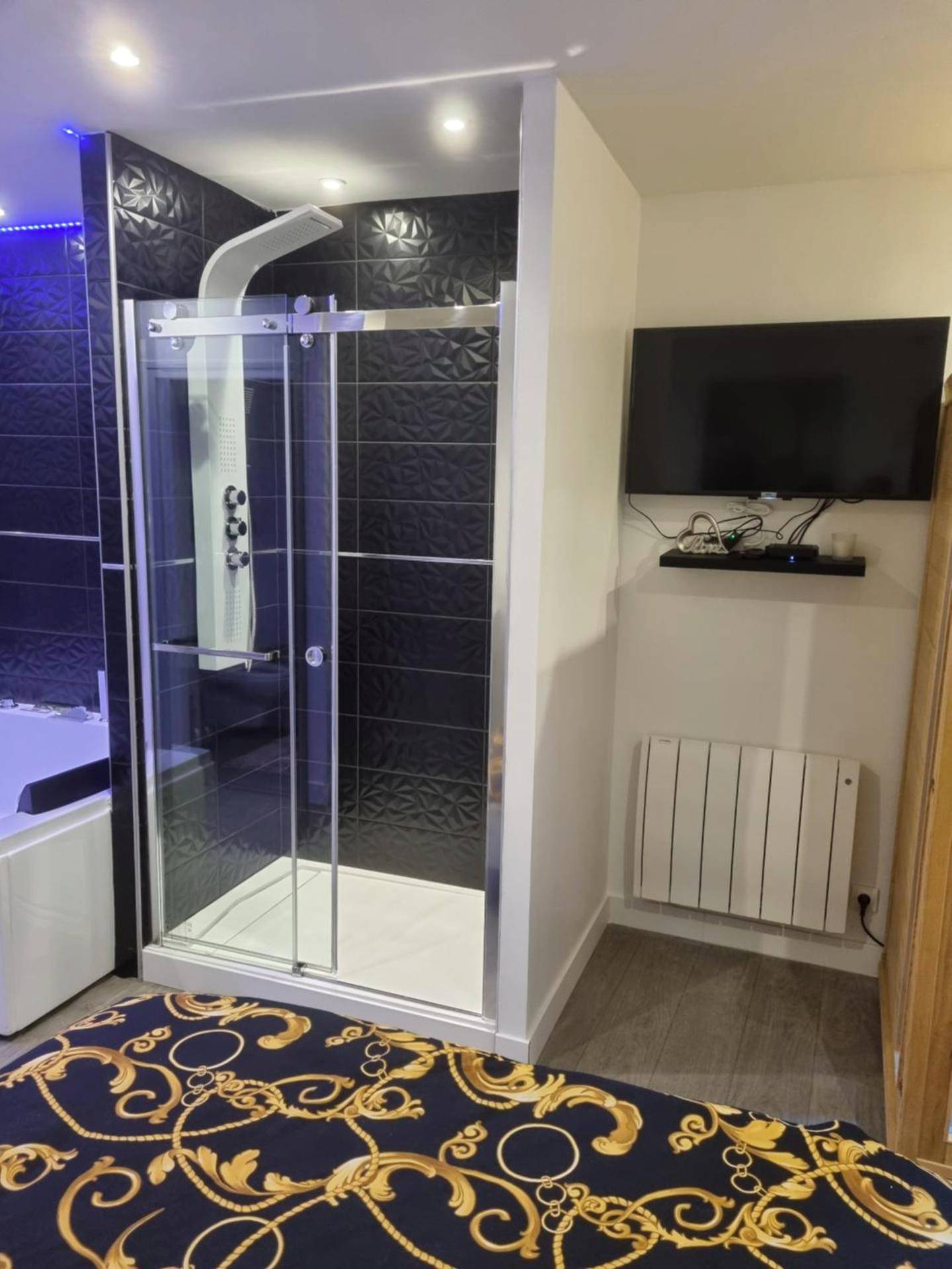 Cabine de douche moderne et télévision murale - appart spa 89