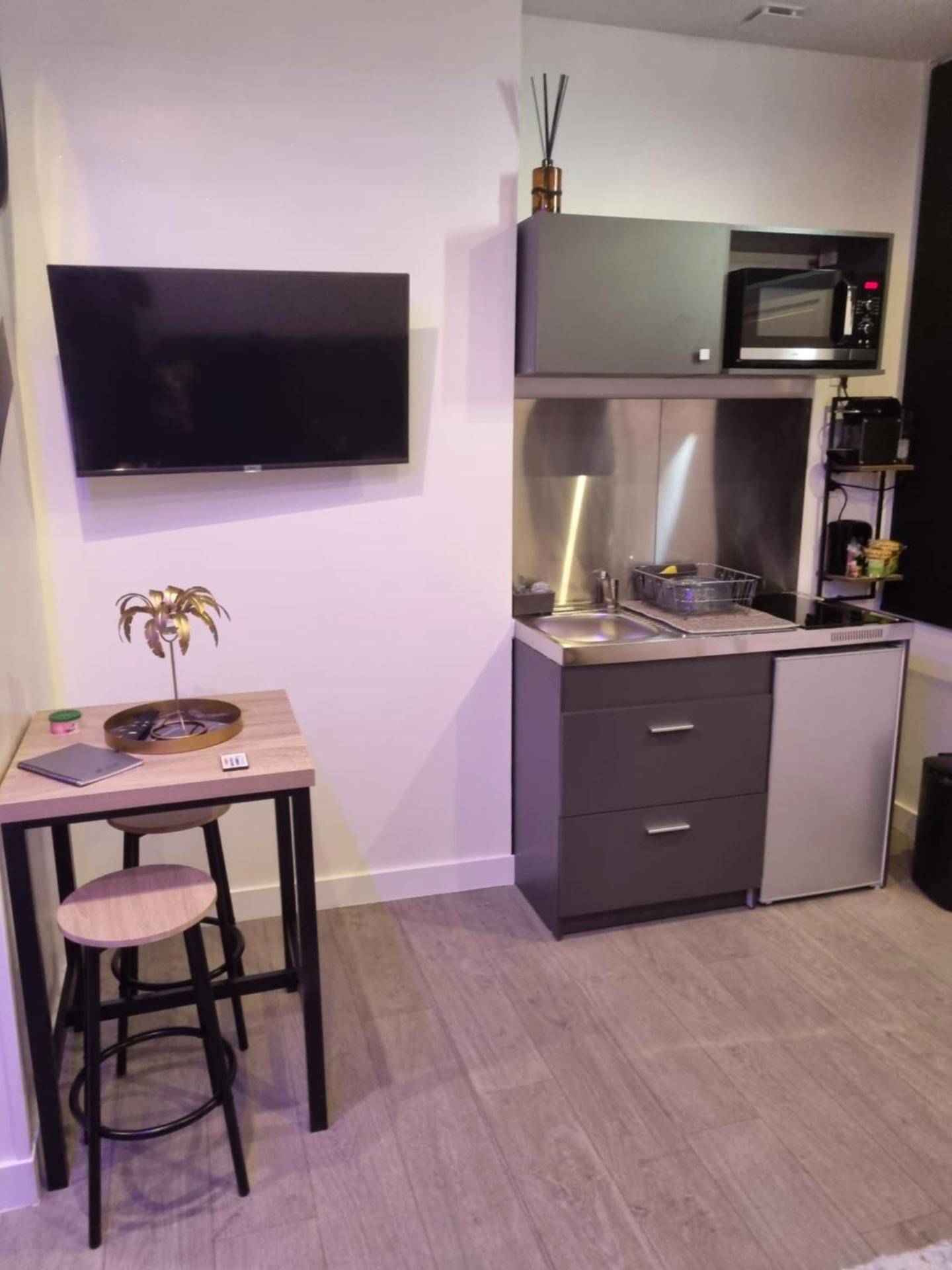 Espace kitchenette et coin repas avec tabourets - appart spa 89