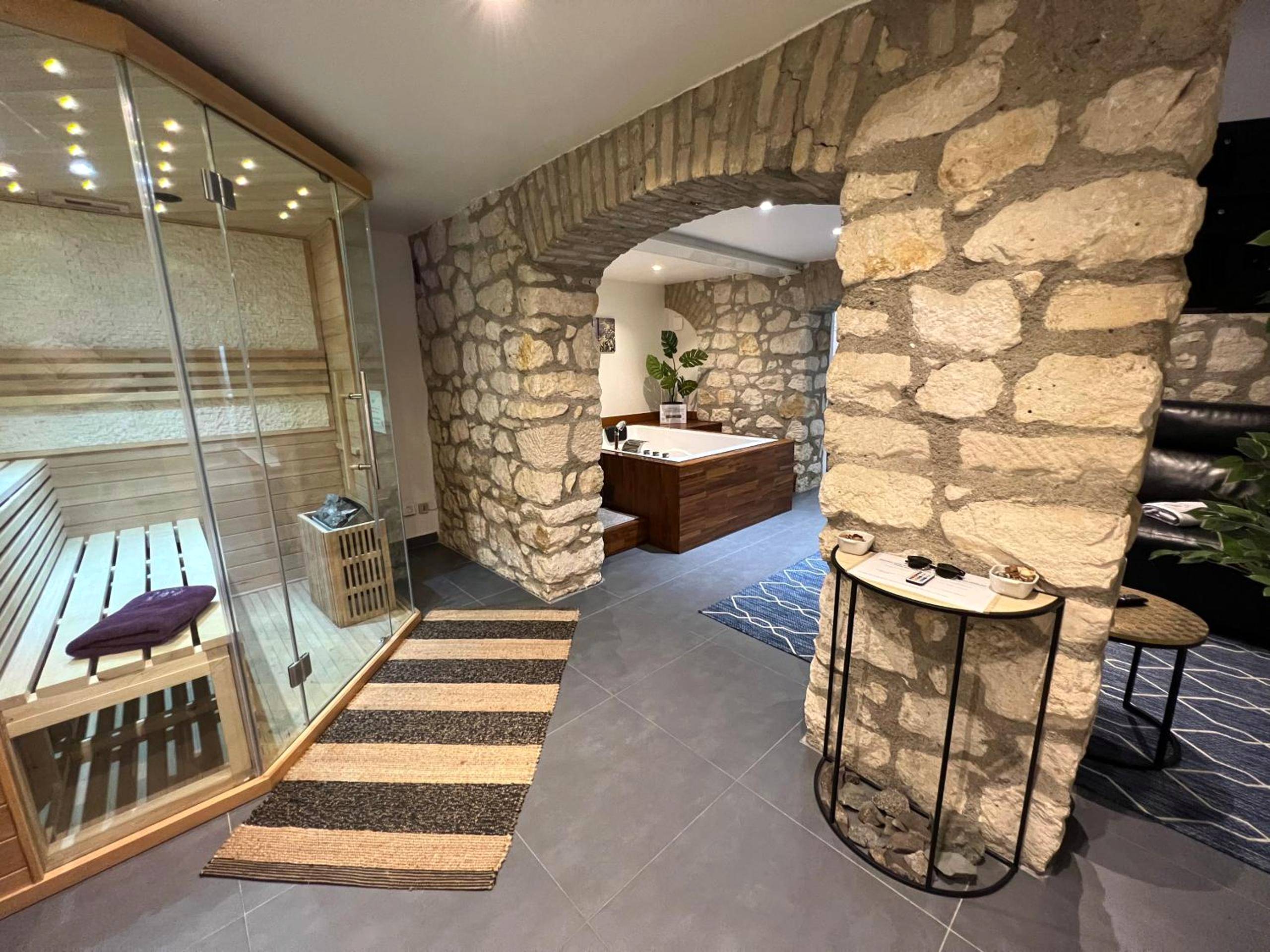 Sauna vitré et murs en pierres apparentes - Appart Spa Privatif