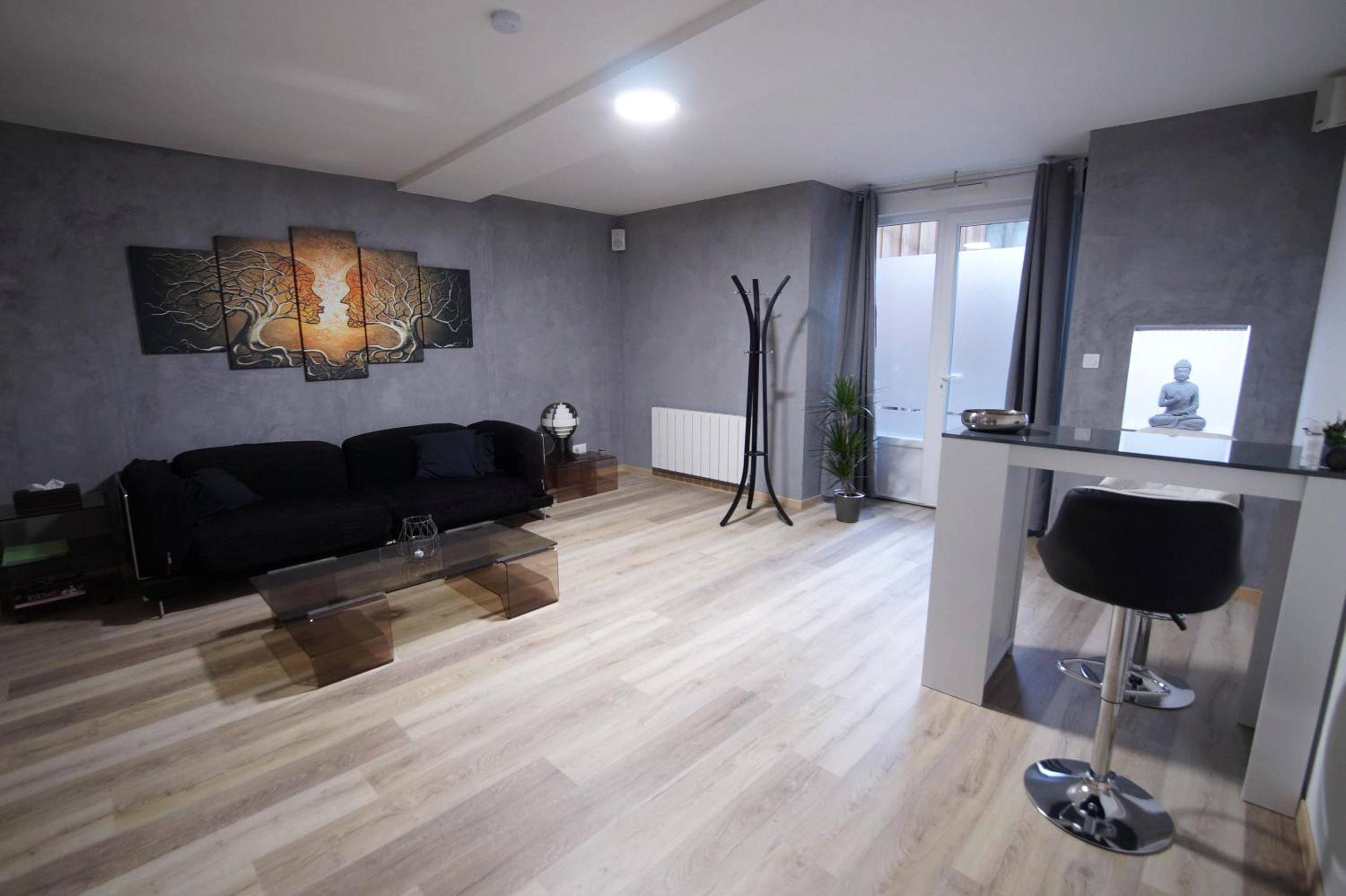 Salon avec canapé noir et table haute - Appart' spa privatif Gray