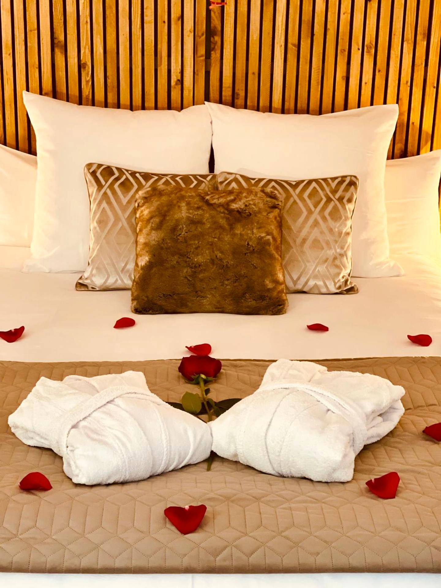 Lit avec pétales de rose et peignoirs blancs - Appart&Spa Devosge