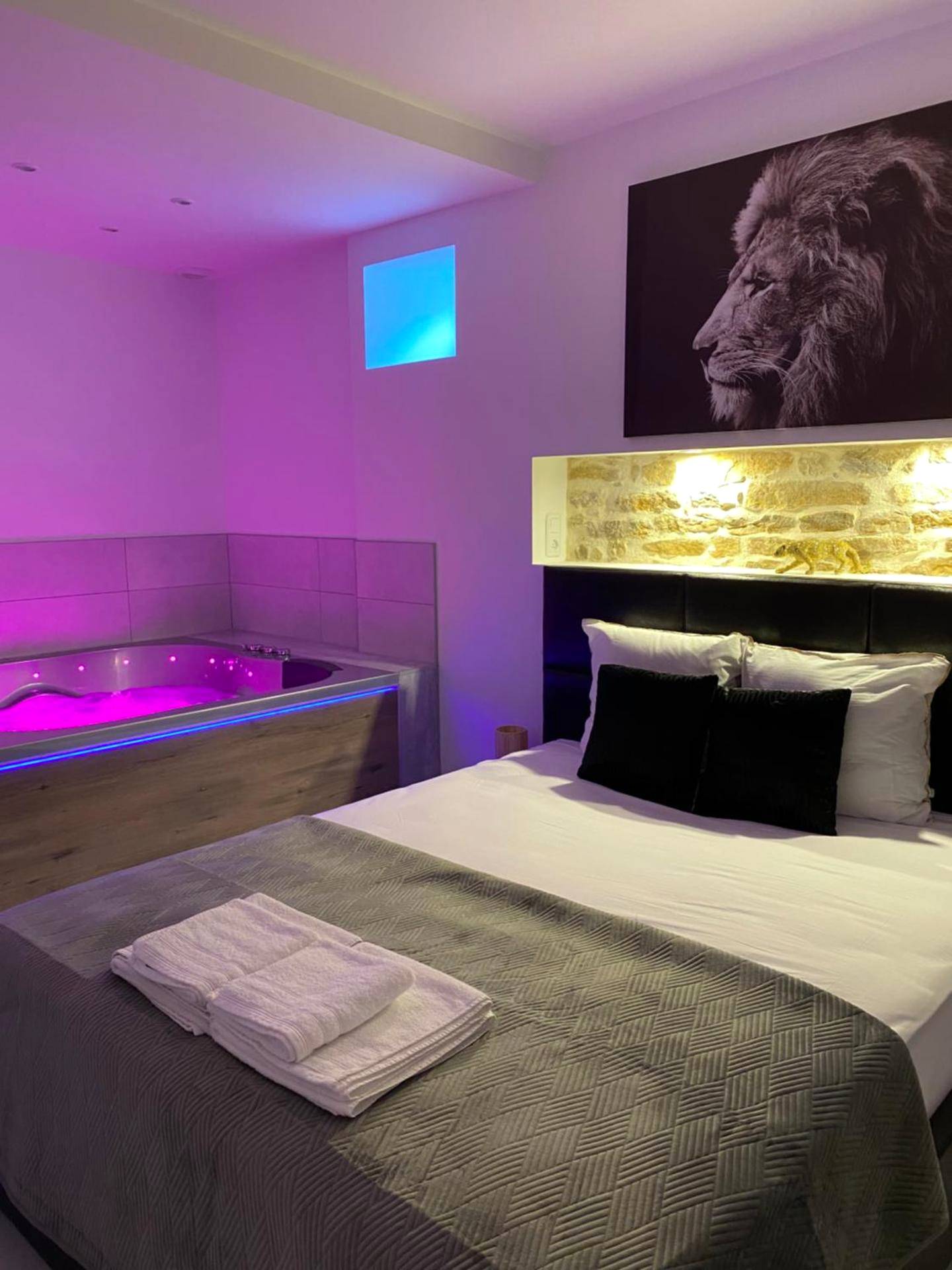 Lit double et jacuzzi avec lumière rose - L’appart [é] spa