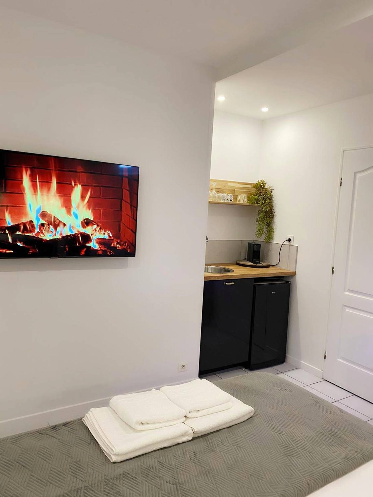 Espace cuisine et TV avec feu de cheminée - L’appart [é] spa