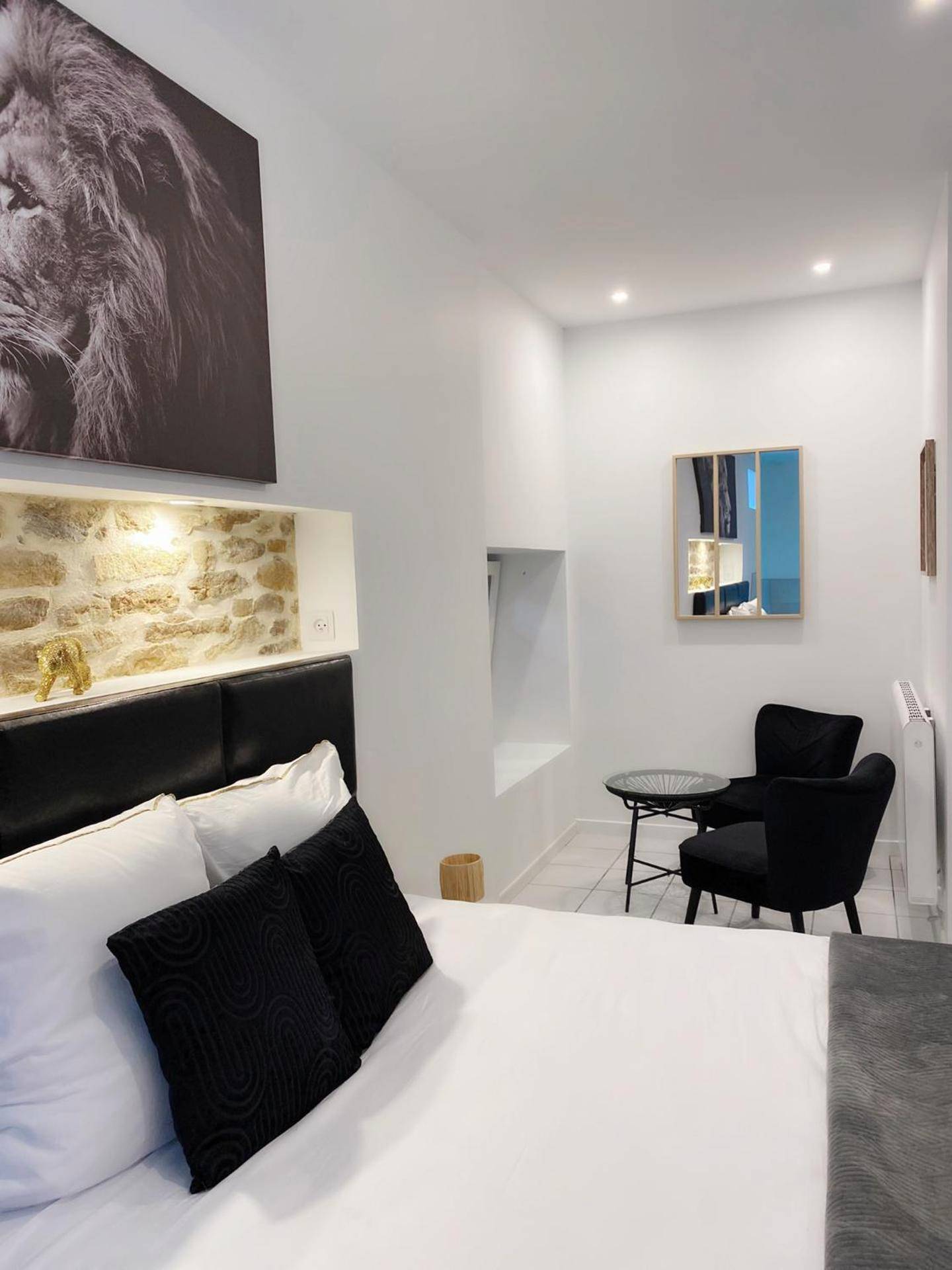 Coin salon avec fauteuils noirs et lit - L’appart [é] spa