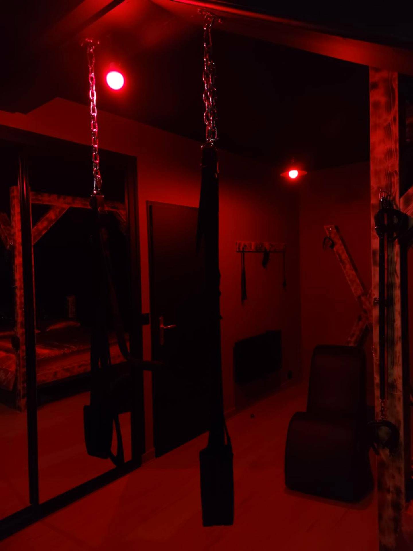 Balançoire érotique sous lumière rouge tamisée - La Love room
