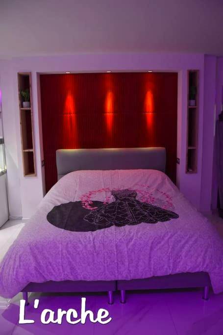 Lit avec tête de lit rouge et spots lumineux - L'Arche Loft nid douillet - L'Arche Loft nid douillet - Spa privatif