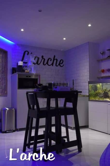 Table haute et tabourets noirs sous néon bleu - L'Arche Loft nid douillet - L'Arche Loft nid douillet - Spa privatif