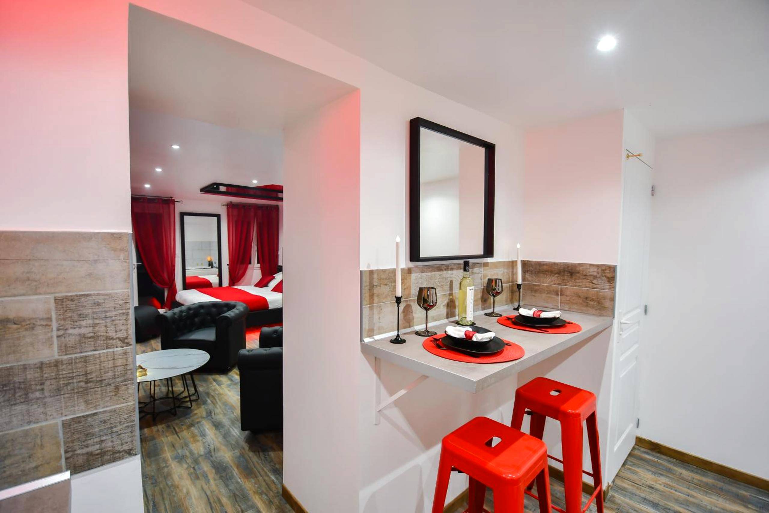 Espace repas avec tabourets rouges et bougies - L'Arena - Love Room, Jacuzzi