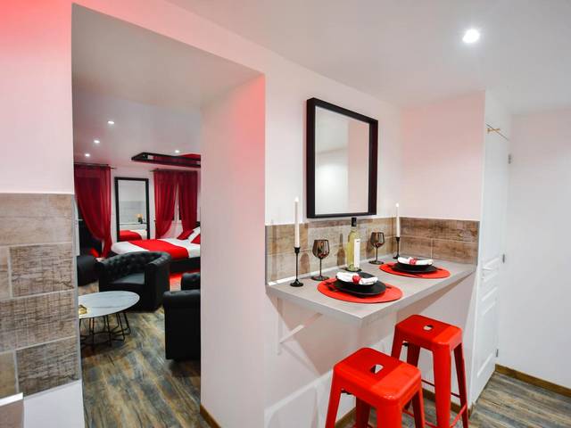 Espace repas avec tabourets rouges et bougies - L'Arena - Love Room, Jacuzzi