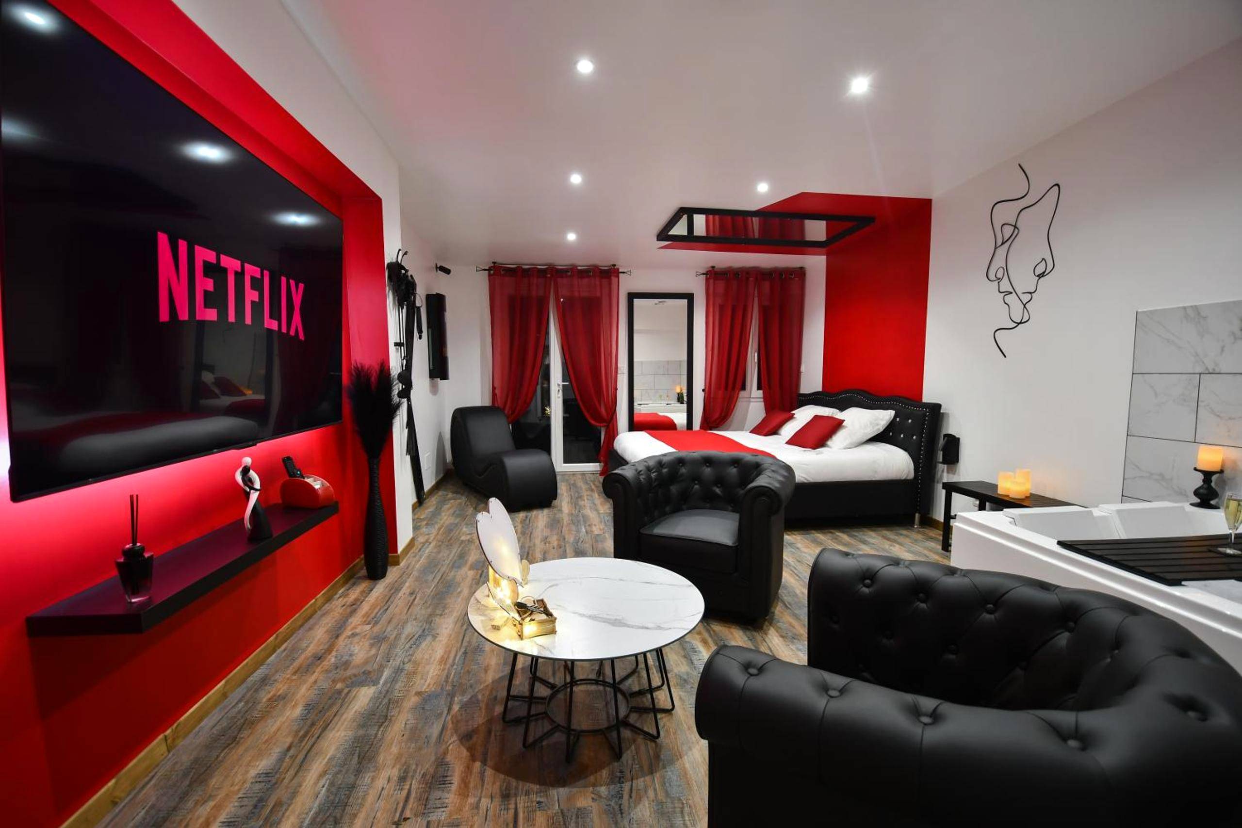 Salon avec fauteuils capitonnés et écran Netflix - L'Arena - Love Room, Jacuzzi