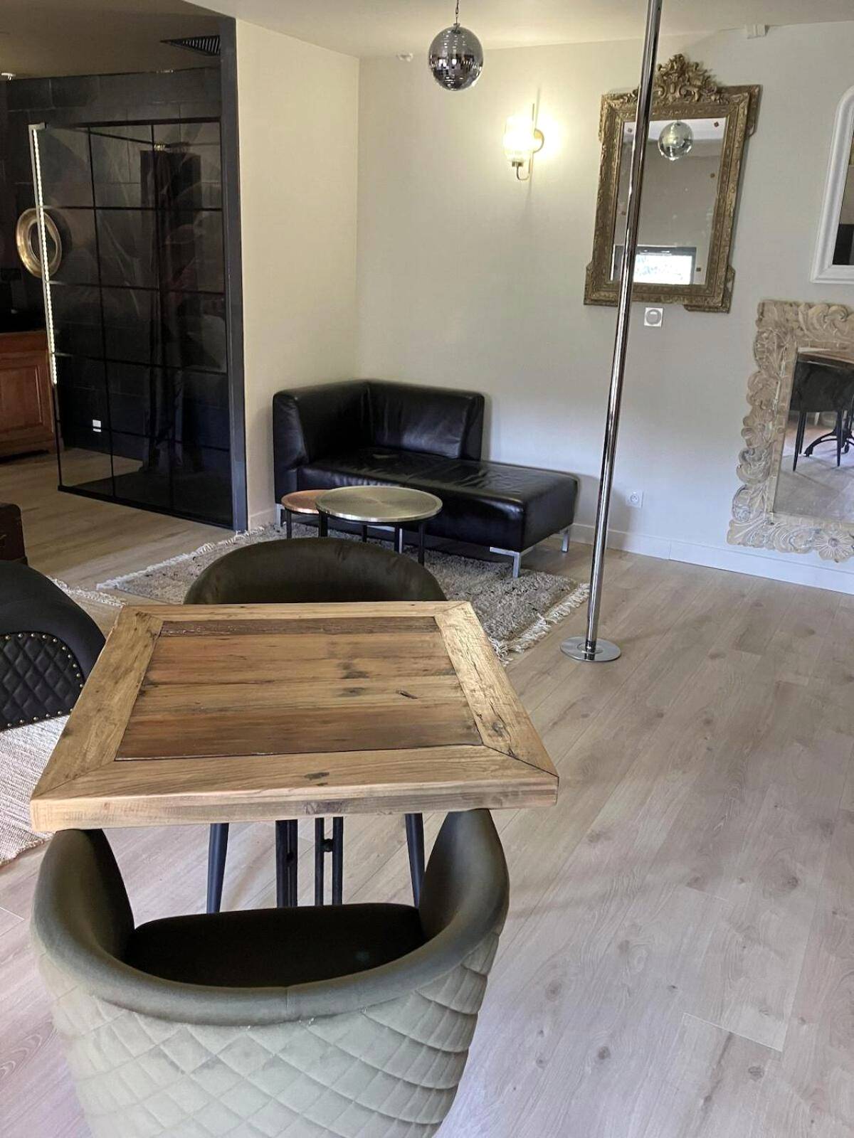 Salon avec barre de pole dance et miroirs dorés - L'Arôme