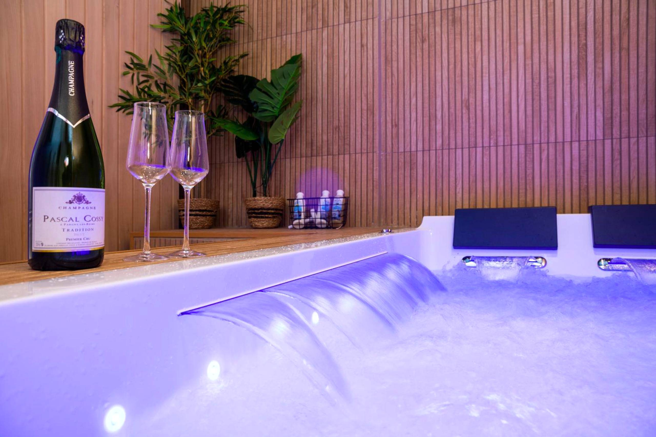 Jacuzzi avec cascade et bouteille de champagne - Love Room Reims - Art Déco Champagne & Spa