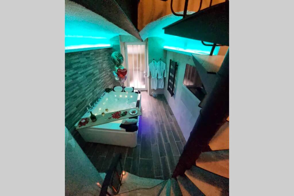 Jacuzzi privatif avec éclairage néon bleu - Love Room Mulhouse - Arty room JACCUZI & SPA CENTRE VILLE HAUT DE GAMME