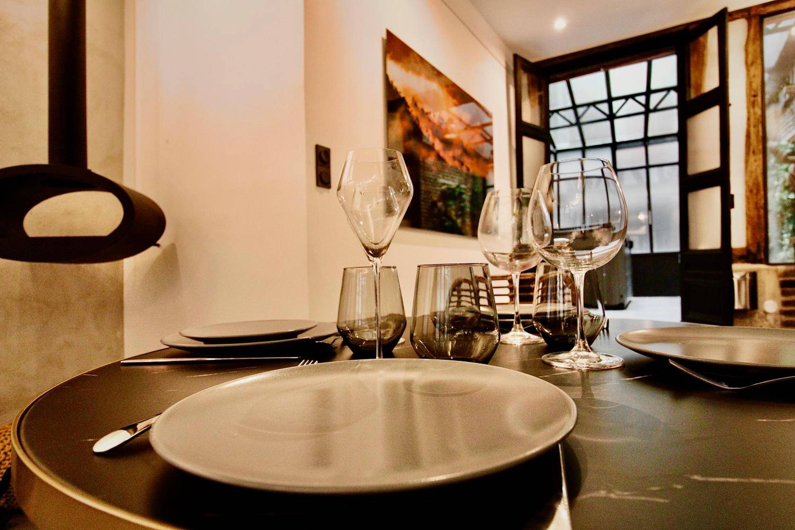 Table dressée avec verres à vin et assiettes - L'Atelier 1742 - Atypique jacuzzi Rouen Centre