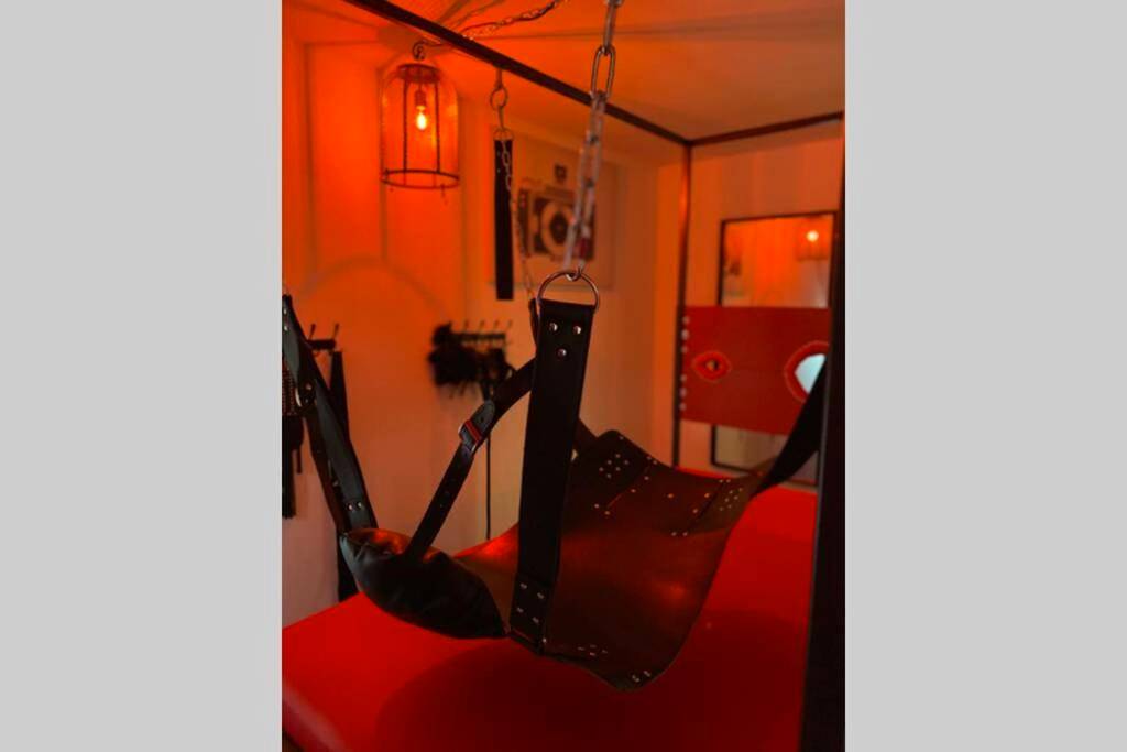 Balançoire érotique en cuir sous lumière rouge - Love Room - L'Atelier Des Nuan'S