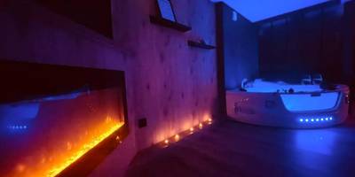 Cheminée électrique et jacuzzi éclairé en bleu - L'Atelier des Rêves - appartement balnéo Rouen
