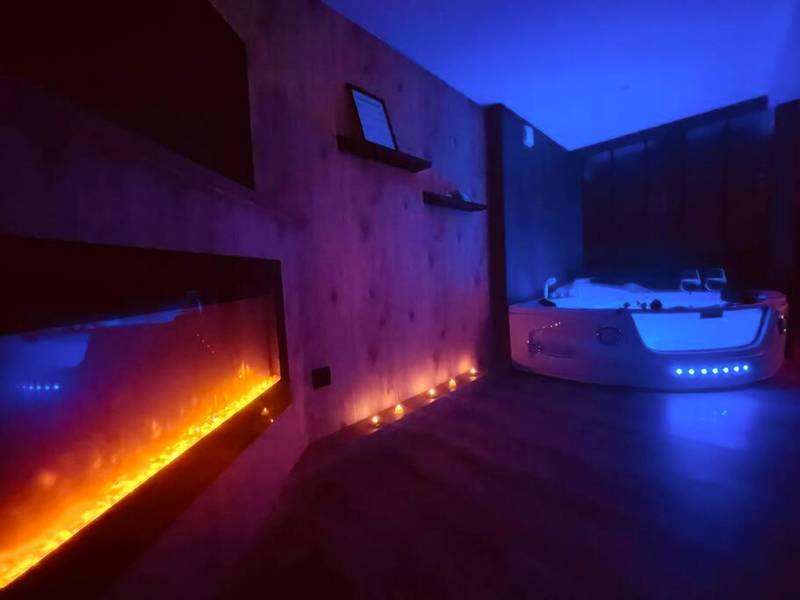 Cheminée électrique et jacuzzi éclairé en bleu - L'Atelier des Rêves - appartement balnéo Rouen