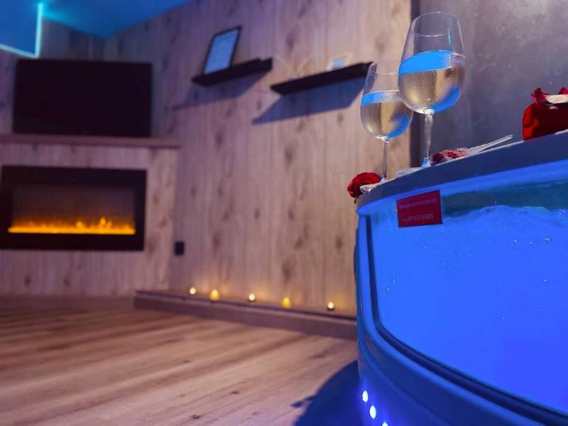 Détail du jacuzzi et cheminée en arrière - plan - L'Atelier des Rêves - appartement balnéo Rouen