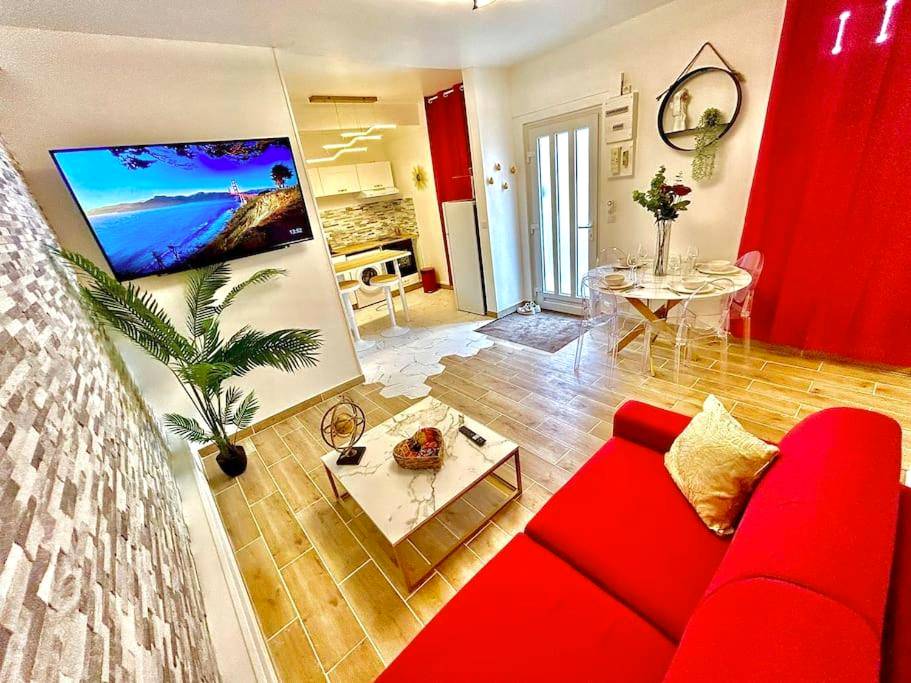 Salon avec canapé rouge et coin cuisine - L’atelier des rêves, jacuzzi