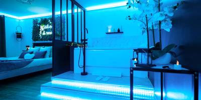 Espace spa et chambre avec éclairage néon bleu - L'Atelier de rêves